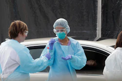 Health care personnel test a person in the passenger seat of a car at a Kaiser Permanente medical center in San Francisco, March 12, 2020.