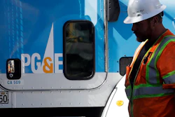 A Pacific Gas & Electric worker walks in front of a truck in San Francisco, Aug. 15, 2019.