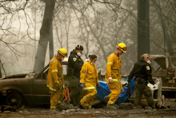 Firefighters and deputies carry the body of a Camp Fire victim at the Holly Hills Mobile Estates in Paradise, Calif., Nov. 14, 2018.