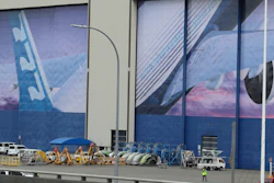 A worker walks near a mural of a Boeing 777 airplane at the company's manufacturing facility in Everett, Wash., March 23, 2020.