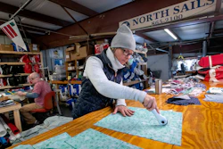 Karen Haley cuts cotton fabric at the North Sails shop in Freeport, Maine, March 23, 2020.