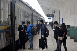 Passengers board a train at the Jingmen Railway Station in Jingmen, China, March 25, 2020.