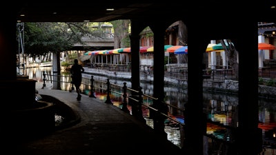 A runner along the mostly deserted River Walk in San Antonio, March 24, 2020.