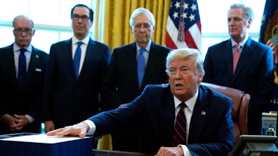 President Donald Trump speaks before he signs the coronavirus stimulus relief package in the Oval Office at the White House, March 27, 2020.