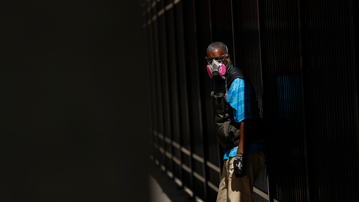 A man wears a protective mask while waiting for a bus in Detroit, April 8, 2020.