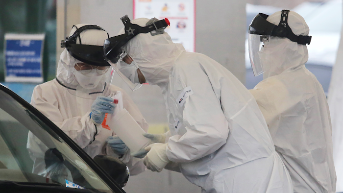 Medical staff at a drive-thru virus test facility in Goyang, South Korea, March 1, 2020.