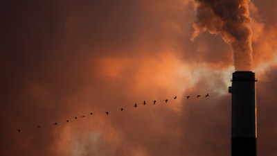 A flock of geese fly past a smokestack at a coal power plant near Emmitt, Kan., Jan. 10, 2009.