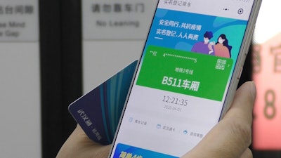 A passenger holds up a green pass on their phone on a subway train in Wuhan, China, April 1, 2020.