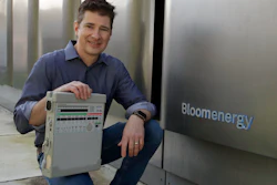 Joe Tavi, Bloom Energy's senior director of manufacturing, holds a refurbished ventilator beside the company's fuel cells, April 1, 2020, in Sunnyvale, Calif.