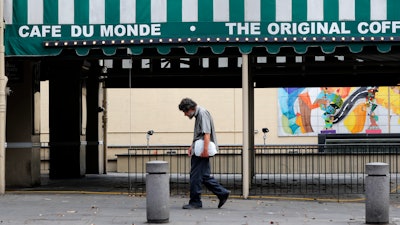 A man walks past the closed Cafe Du Monde restaurant in New Orleans, March 27, 2020.