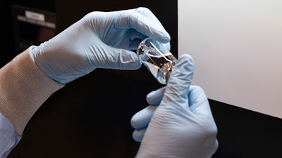 A vial of the investigational drug remdesivir is inspected at a Gilead manufacturing site, March 2020.