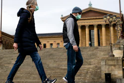 A couple in protective masks walk past the Philadelphia Museum of Art, April 3, 2020.
