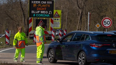 Regulators turn back non-essential traffic on a road leading to the beach resort of Zandvoort, Netherlands, April 4, 2020.