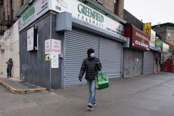 A woman walks by closed stores in New York, April 3, 2020.