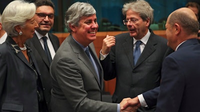 Eurogroup President Mario Centeno, center, shakes hands with German Finance Minister Olaf Scholz, Jan. 20, 2020.