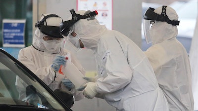 Medical staff at a drive-thru virus test facility in Goyang, South Korea, March 1, 2020.