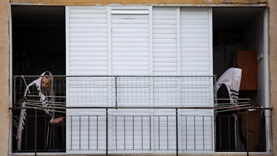 Ultra-Orthodox Jews pray at their house in Bnei Brak, Israel, April 14, 2020.