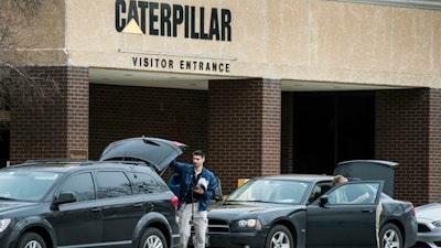 Federal officials gather at their vehicles as they continue to execute a search warrant at the Caterpillar, Inc. facility in Morton, Ill., one of three Caterpillar facilities they are searching in the Tri-County area Thursday, March 2, 2017.