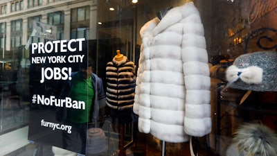 This April 10, 2019, photo shows a sign by furnyc.org in the window of Victoria Stass Collection in New York's fur district. The fur trade is considered so important to New York’s development that two beavers adorn the city’s official seal, a reference to early Dutch and English settlers who traded in beaver pelts.