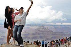 Tourists Joseph Lin, Ning Chao, center, and Linda Wang, left, pose along the south rim at Grand Canyon National Park, Ariz., Aug. 2, 2015.