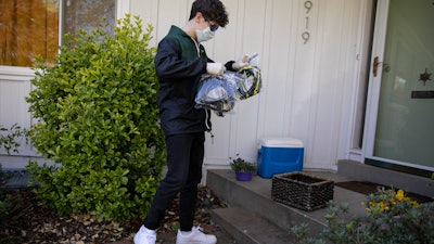 Will Olsen, 17, picks up bags holding pieces for medical face shields that were printed using personal 3D printers, Kensington, Md., April 19, 2020.