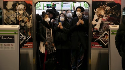 Commuters wearing masks stand in a packed train at the Shinagawa Station in Tokyo, March 2, 2020.