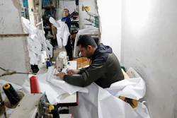 In this Monday, March 30, 2020 file photo, Palestinians make protective overalls meant to shield people from the coronavirus, to be exported to Israel, at a local factory, in Gaza City.