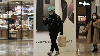 A man passes by an advertisement of Samsung's Galaxy S20 Ultra and Galaxy Z Flip smartphones at its shop in Seoul, April 28, 2020.