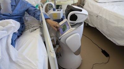 A coronavirus patient uses the touch screen of a robot at Ospedale di Circolo hospital, Varese, Italy, April 8, 2020.