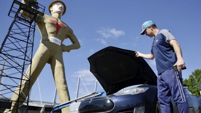 Andrew Nelson lifts the hood of his Tesla Model S in front of the Golden Driller as it gets a Tesla facelift, May 19, 2020.