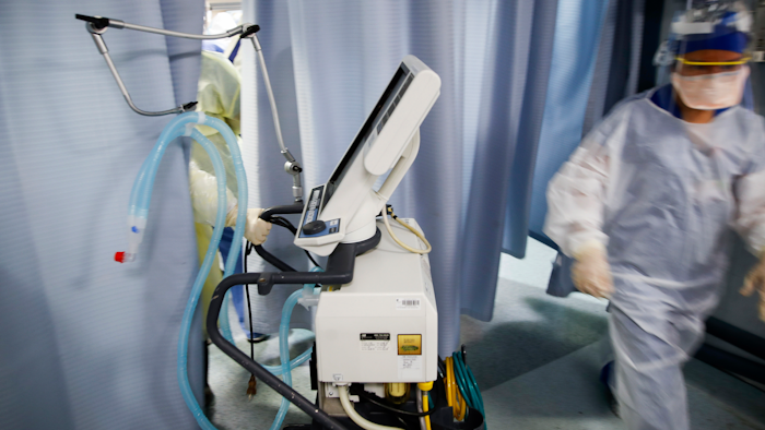 A nurse pulls a ventilator into an exam room at St. Joseph's Hospital in Yonkers, N.Y., April 20, 2020.
