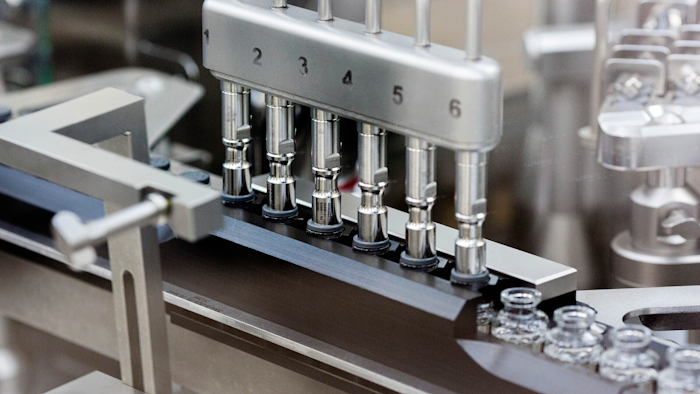 Rubber stoppers are placed onto filled vials of the investigational drug remdesivir at a Gilead manufacturing site, March 2020.