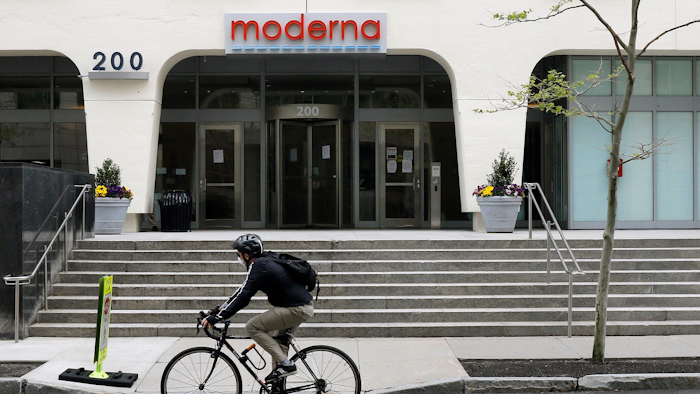 A bicyclist pedals past an entrance to a Moderna building, Cambridge, Mass., May 18, 2020.