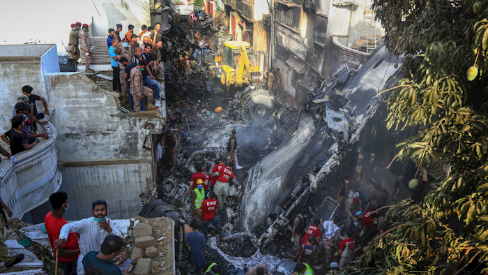 Volunteers look for survivors of a plane that crashed in a residential area of Karachi, Pakistan, May 22, 2020.