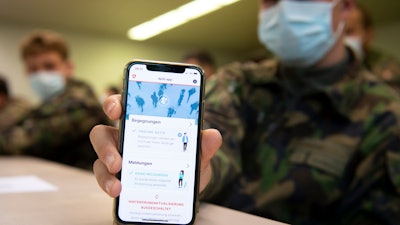A Swiss soldier holds a smartphone with an app using Decentralized Privacy-Preserving Proximity Tracing (DP-3T) during a test near Yverdon-les-Bains, Switzerland, April 30, 2020.