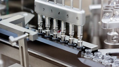 Rubber stoppers are placed onto filled vials of the investigational drug remdesivir at a Gilead manufacturing site, March 2020.