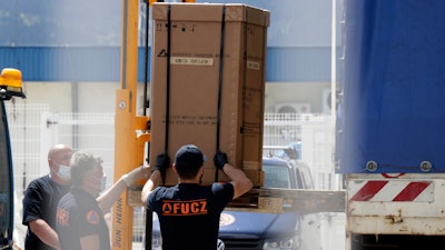 Civil protection workers move boxes of ventilators at the customs post in Sarajevo, April 30, 2020.