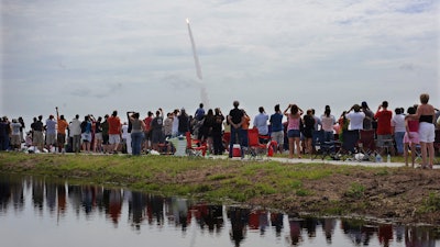 Spectators watch the space shuttle Atlantis lift off from the Kennedy Space Center at Cape Canaveral, Fla., July 8, 2011.