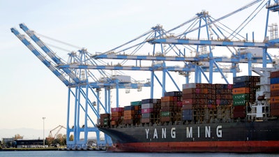 Cargo cranes take containers off a Yang Ming Marine boat at the Port of Tacoma, Tacoma, Wash., Nov. 4, 2019.