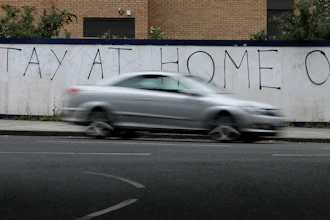 A car passes graffiti during the lockdown in London, April 13, 2020.