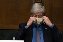 National Institutes of Health Director Dr. Francis Collins puts on his face mask after a Senate committee hearing on new coronavirus tests on Capitol Hill, May 7, 2020.
