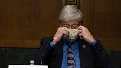 National Institutes of Health Director Dr. Francis Collins puts on his face mask after a Senate committee hearing on new coronavirus tests on Capitol Hill, May 7, 2020.