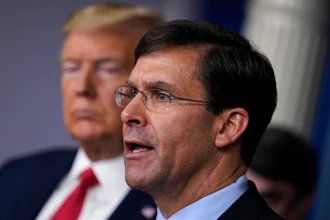 Defense Secretary Mark Esper speaks as President Donald Trump listens during a press briefing at the White House, March 18, 2020.