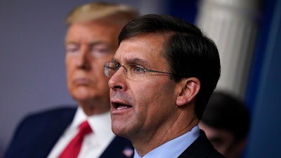 Defense Secretary Mark Esper speaks as President Donald Trump listens during a press briefing at the White House, March 18, 2020.