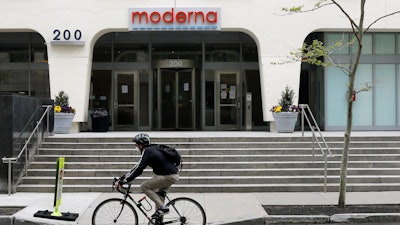 A bicyclist pedals past an entrance to a Moderna building, Cambridge, Mass., May 18, 2020.