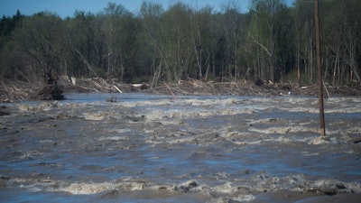 Floodwaters rush through the path of where the Edenville Dam once stood north of Midland, Mich., May 20, 2020.