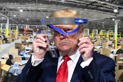 President Donald Trump looks through a face shield.