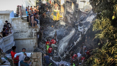 Volunteers look for survivors of a plane that crashed in a residential area of Karachi, Pakistan, May 22, 2020.
