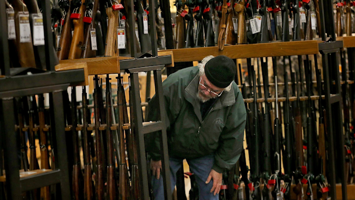 A man looks at the shotgun section at a Cabela's in Hazelwood, Mo., Nov. 29, 2019.