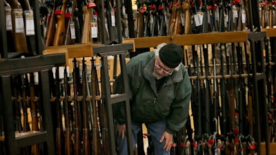 A man looks at the shotgun section at a Cabela's in Hazelwood, Mo., Nov. 29, 2019.
